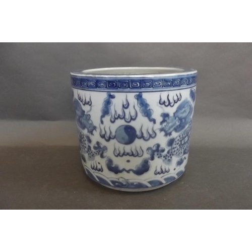 87 - A Chinese blue and white porcelain brush pot decorated with dragons chasing the flaming pearl, 5½