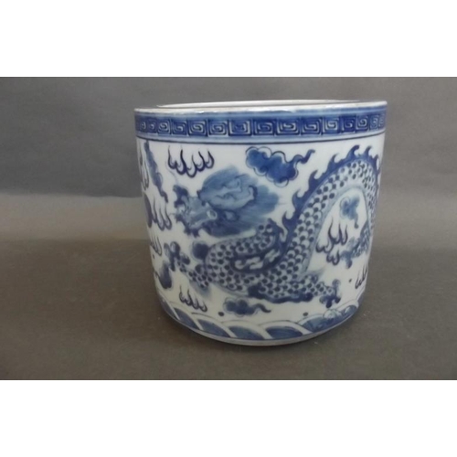 87 - A Chinese blue and white porcelain brush pot decorated with dragons chasing the flaming pearl, 5½