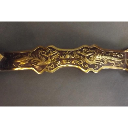 89 - A Chinese gilt bronze ruyi with raised phoenix decoration, 14