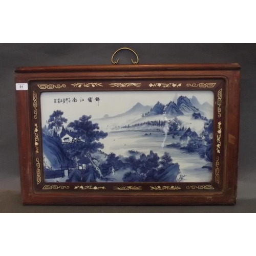 91 - A Chinese blue and white porcelain panel depicting a riverside village landscape with distant mounta... 