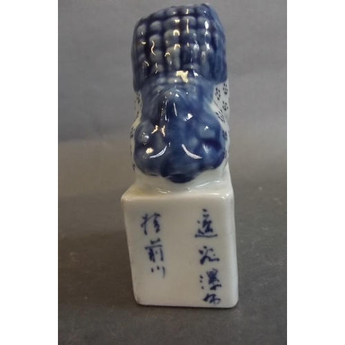 93 - A Chinese blue and white porcelain seal, the top formed as a Fo dog seated on a plinth base with ins... 