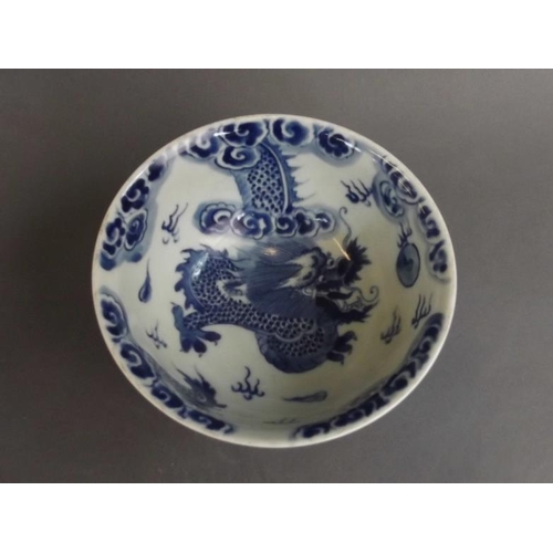 15 - A Chinese blue and white porcelain rice bowl with dragon decoration on an ochre glazed ground, seal ... 