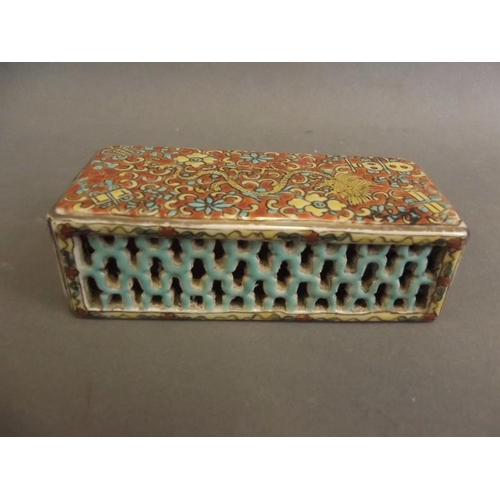 36 - A Chinese porcelain scroll weight of rectangular form with pierced sides, the top decorated in brigh... 