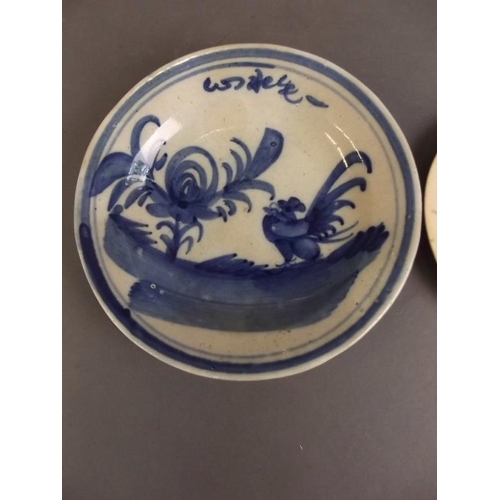 50F - An antique Chinese blue and white stoneware plate decorated with a cockerel and tree, together with ... 