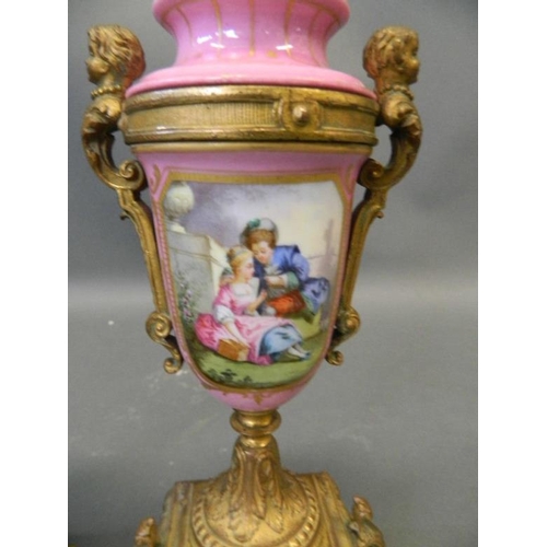 50N - A pair of pink ground Sevres style side urns with ormolu mounts and painted decoration of courting c... 