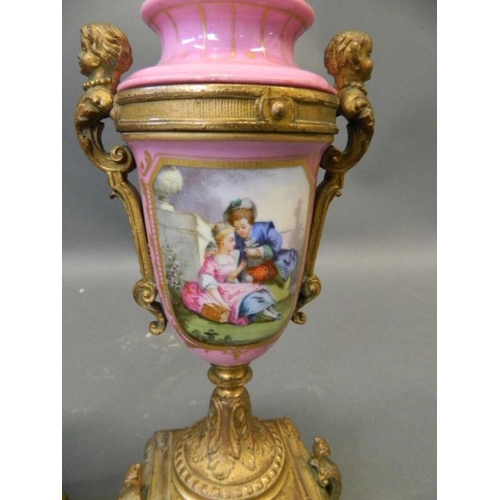 50N - A pair of pink ground Sevres style side urns with ormolu mounts and painted decoration of courting c... 