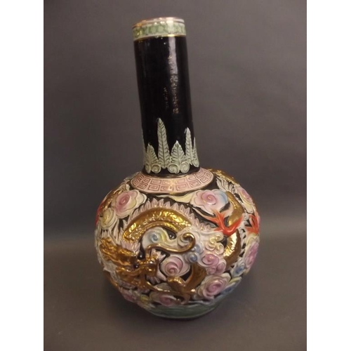 50V - A large Chinese porcelain long necked vase, the bulbous base with embossed dragon and floral decorat... 