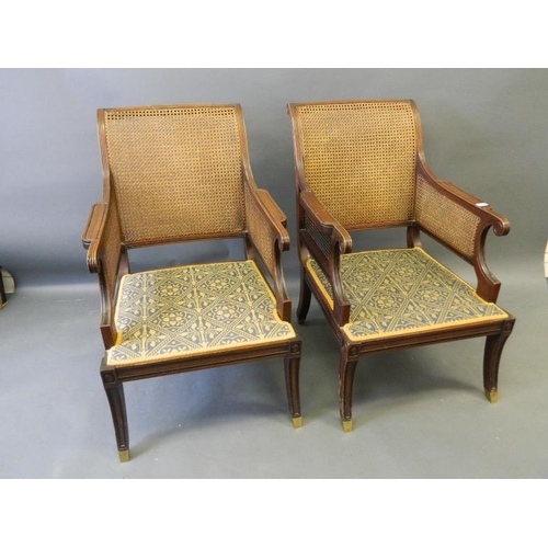 815 - A pair of Regency style mahogany bergère library chairs with ebonised decoration, raised on sabre su... 