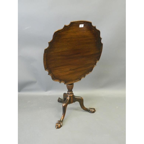 818 - A C19th mahogany tilt-top occasional table with shaped dish top, on a carved and turned column and t... 