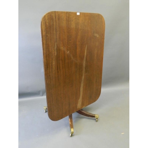 821 - An early C19th mahogany tilt-top breakfast table, on ring turned column base and four reeded sabre s... 