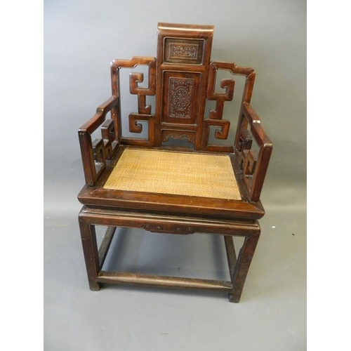 823 - A Chinese hardwood throne chair with carved back panels and scroll arms, 23½