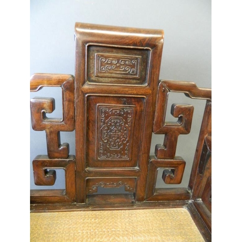 823 - A Chinese hardwood throne chair with carved back panels and scroll arms, 23½