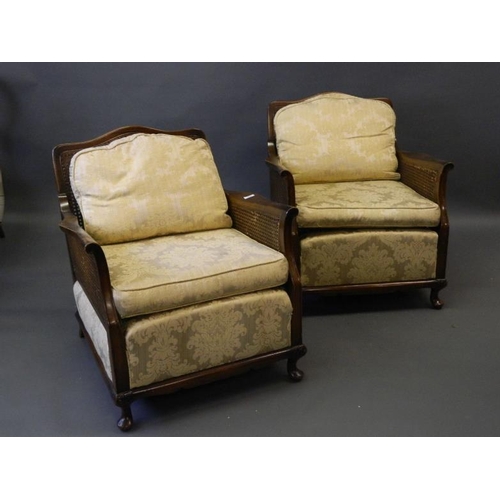 824 - A pair of Bergère armchairs with shaped apron raised on carved cabriole supports