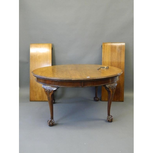 825 - A Victorian oval walnut wind out dining table with two leaves, raised on carved cabriole supports an... 