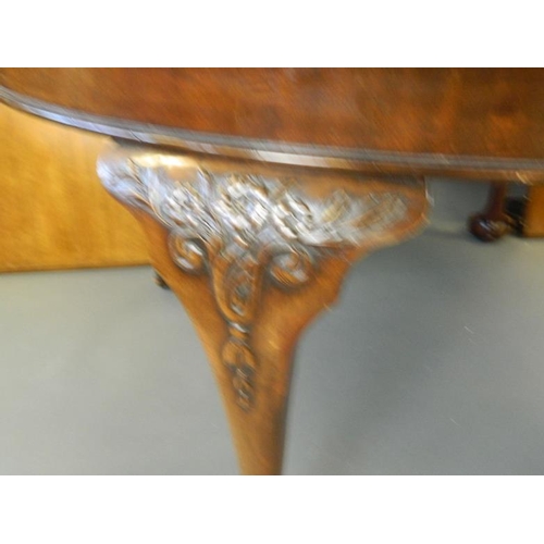 825 - A Victorian oval walnut wind out dining table with two leaves, raised on carved cabriole supports an... 