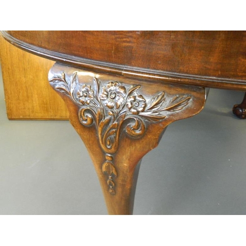 825 - A Victorian oval walnut wind out dining table with two leaves, raised on carved cabriole supports an... 