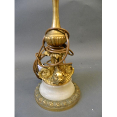 833 - A brass fluted column standard lamp, on a cast base with four dolphins, 62