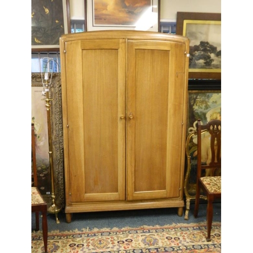 834 - A Heal's walnut two door wardrobe raised on shaped supports, bears ivorine label 'Heal & Son Ltd', m... 