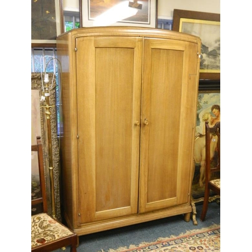 834 - A Heal's walnut two door wardrobe raised on shaped supports, bears ivorine label 'Heal & Son Ltd', m... 