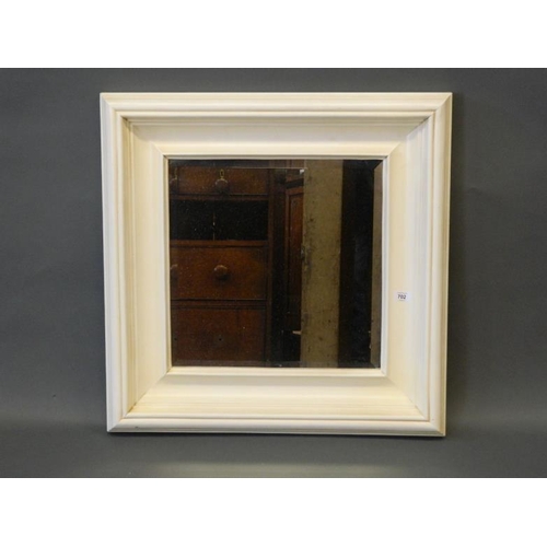 857 - A square bevelled glass wall mirror in a painted frame, 27