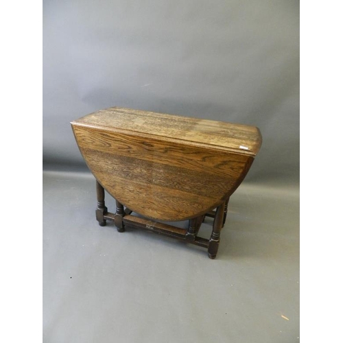 865 - A mid C20th oak drop leaf table on turned supports and gateleg action, 41