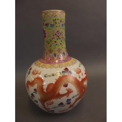 32 - A Chinese porcelain bulbous vase with slender neck, the body painted in bright enamels with dragons ... 