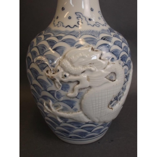 38 - A Chinese porcelain bottle vase with relief dragon and flaming pearl decoration, impressed seal mark... 