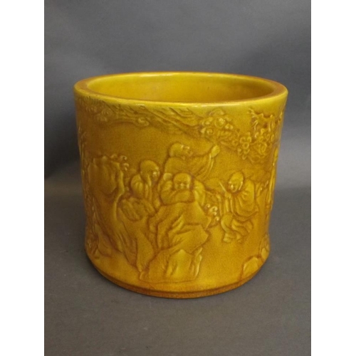 46 - A Chinese mustard yellow crackle glazed brush pot with relief decoration of immortals and their foll... 