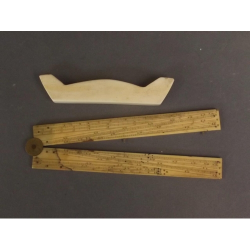 50D - An ivory folding rule, and an antique carved ivory knife rest, rule 12