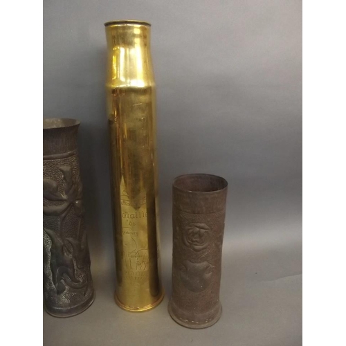 50J - A pair of Trench art shell case vases decorated with flowers and shields, another similar, and a pol... 