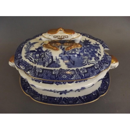 9 - A Royal Worcester blue and white 'Willow' pattern sauce tureen with lid and stand, with gilt embelli... 