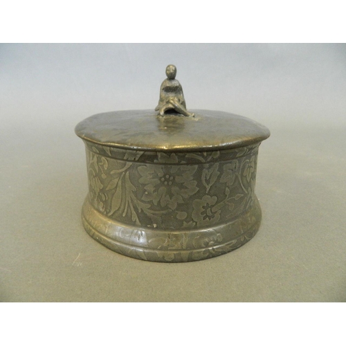 35 - An antique pewter begging bowl with all over engraved leaf decoration, the lid with cast knop in the... 