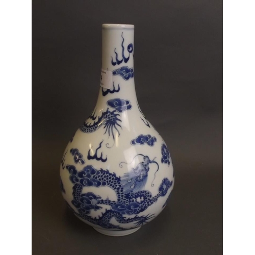 4 - A Chinese blue and white porcelain bottle vase with painted decoration of dragons chasing the flamin... 