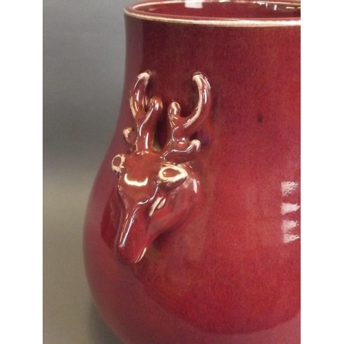 35 - A Chinese flambé glazed pottery vase with twin deer mask handles and crackle glazed interior, 11