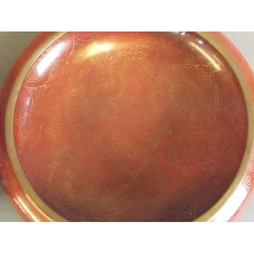 49 - A Chinese cloisonné shallow bowl with deep red ground and dragon decoration, seal mark to base, toge... 