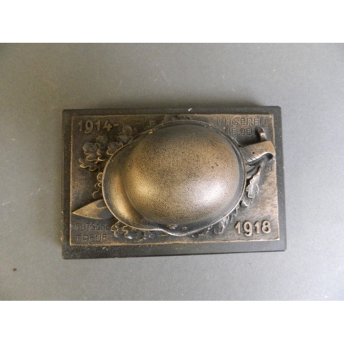 36 - A bronzed composition paperweight in the form of a German military helmet and knife commemorating WW... 