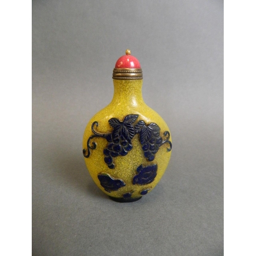 40 - A Peking glass snuff bottle with carved and blue enamelled decoration of poultry and fruiting vines ... 