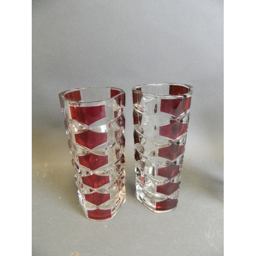 48 - A collection of three cut glass vases, together with a pair of triform crystal vases with cranberry ... 