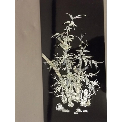 50N - A Chinese lacquered panel inset with Mother of Pearl depicting birds amongst bamboo, 12