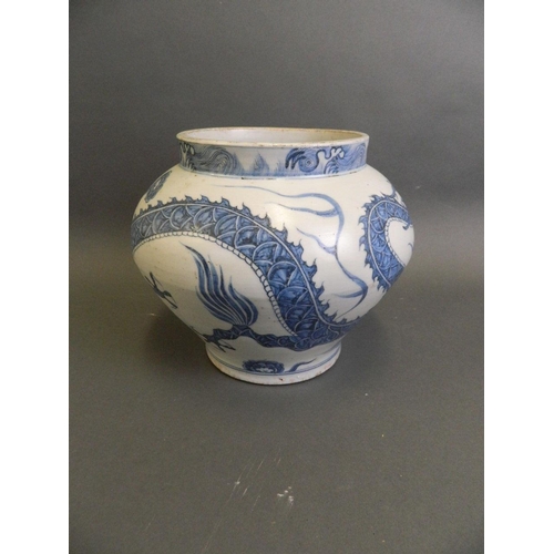 147 - A Chinese Ming style blue and white pottery jardinière with painted decoration of a dragon chasing t... 