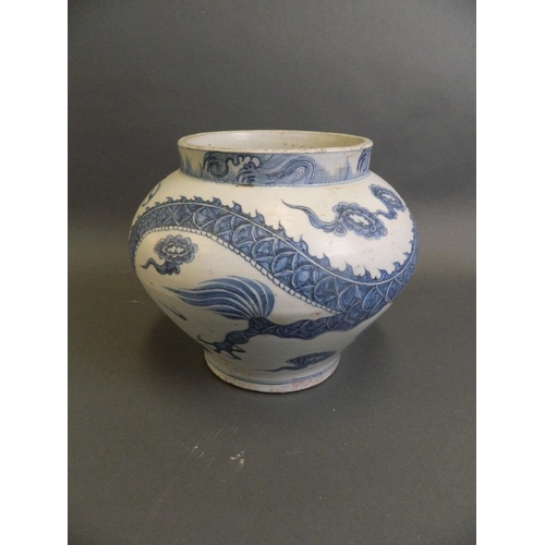 147 - A Chinese Ming style blue and white pottery jardinière with painted decoration of a dragon chasing t... 