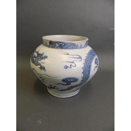 147 - A Chinese Ming style blue and white pottery jardinière with painted decoration of a dragon chasing t... 