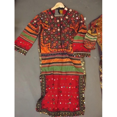 150E - Three Afghan women's silk dresses with decorative embroidery and inset mirror glass decoration, larg... 