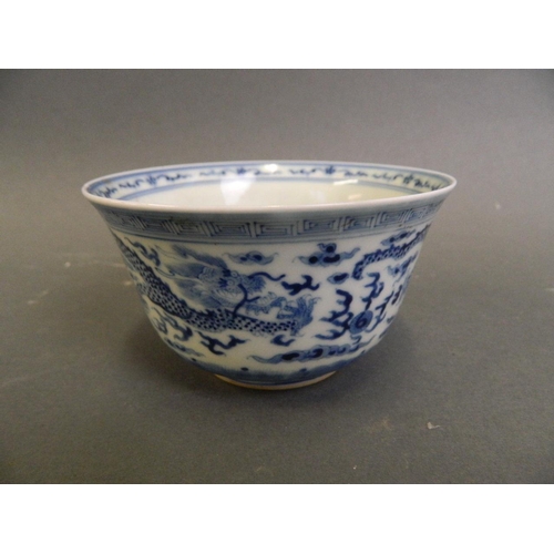 166 - A Chinese blue and white porcelain rice bowl decorated with twin dragons chasing the flaming pearl, ... 