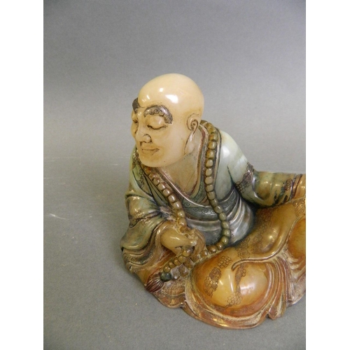 167 - A Chinese soapstone carving of Lohan reclining, 4½