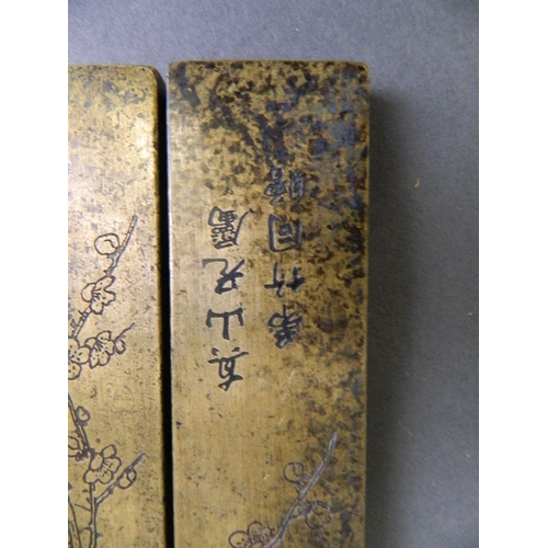 179 - A pair of Chinese bronze rectangular scroll weights with engraved bamboo, prunus and cypress tree de... 