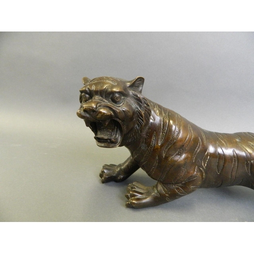 182 - A Chinese bronze figure of a prowling tiger, 12½