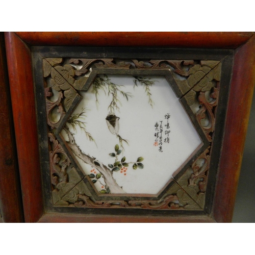 184 - A pair of Chinese porcelain and carved hardwood panels containing four famille verte plaques depicti... 