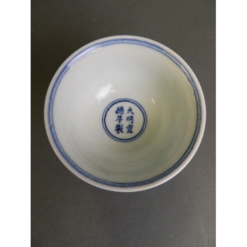 210 - A Chinese blue and white porcelain stem cup with incised decoration of mythical creatures above wave... 