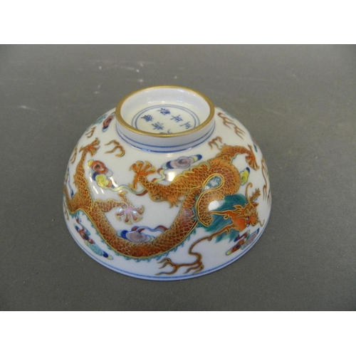 211 - A Chinese Doucai enamelled porcelain rice bowl decorated with twin dragons chasing the flaming pearl... 